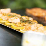 Gegrillter Lachs auf Zitronenscheiben mit frischen Kräutern.