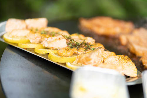 Gegrillter Lachs auf Zitronenscheiben mit frischen Kräutern.