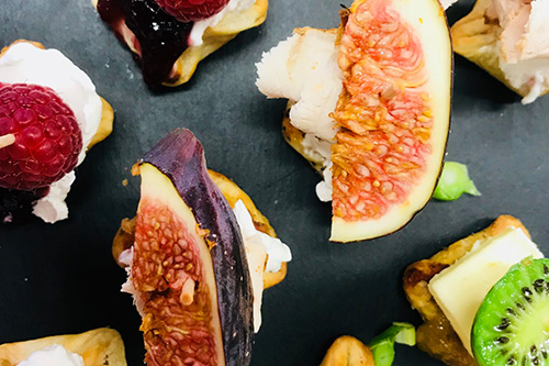 Bunte Fingerfood-Häppchen mit Feigen, Kiwi, Himbeeren und Käse.