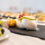 Burrata auf Schieferplatte mit Limette, Physalis und roten Beeren.