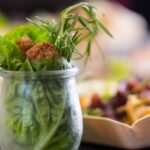 Vegetarisches Fingerfood im Glas mit Salat, Bällchen und Rosmarin.